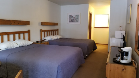 A chalet style room on the first floor with two queen beds. This room has a 4 cup coffee pot, mini fridge and micro wave. There is a flat screen TV mounted on the wall at the foot of the beds.